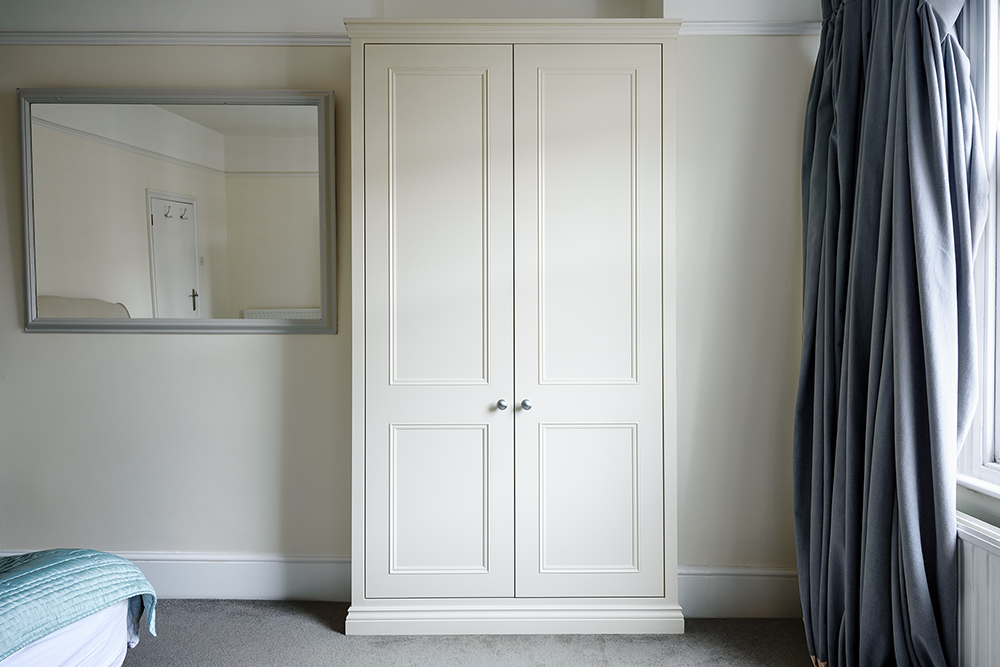 Built-in white alcove wardrobe with 2 doors. Designed and installed by carpenters and joiners at Bespoke Carpentry London.
