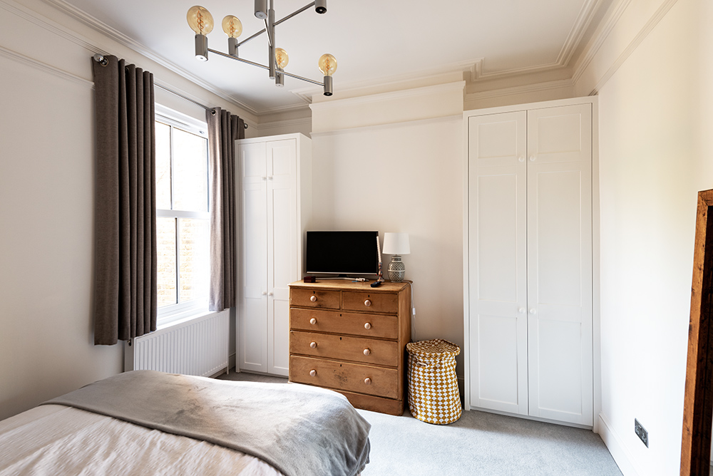 White fitted alcove wardrobes in bedroom, made with MDF