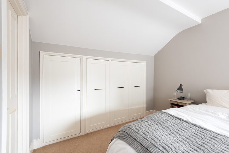Bespoke under eaves wardrobe in bedroom. Built by carpenters at Bespoke Carpentry London.