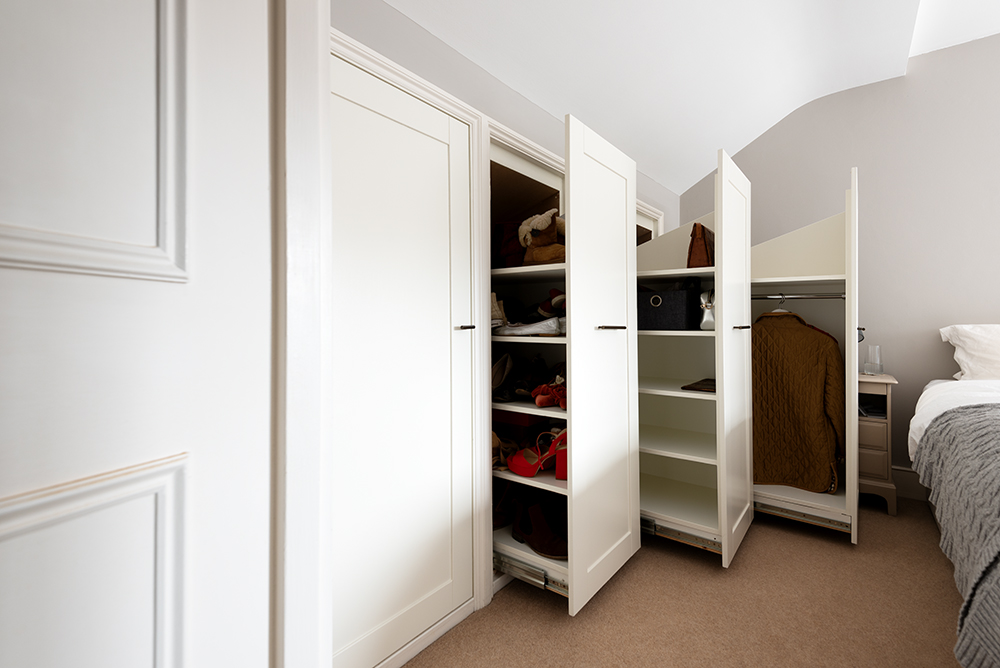 Fitted under eaves wardrobe in bedroom. Designed and installed by carpenters and joiners at Bespoke Carpentry London.