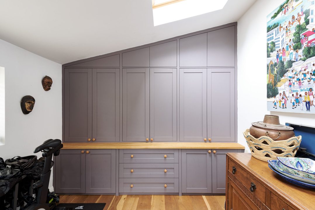 Grey built-in slanted loft wardrobe in spare room