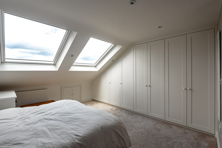 Bespoke slanted wardrobe in loft room. Designed and installed by carpenters and joiners at Bespoke Carpentry London.