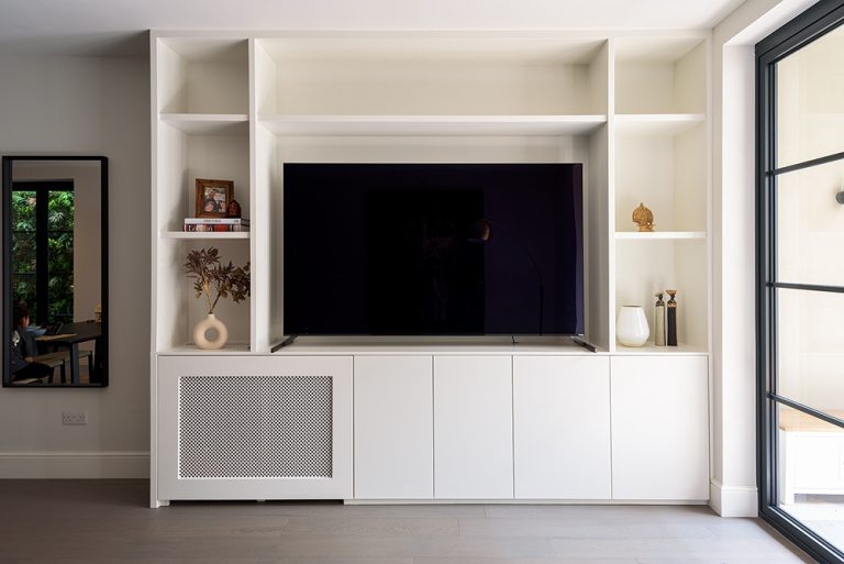 White built-in tv unit in living room. Designed and installed by local carpenters at Bespoke Carpentry London.
