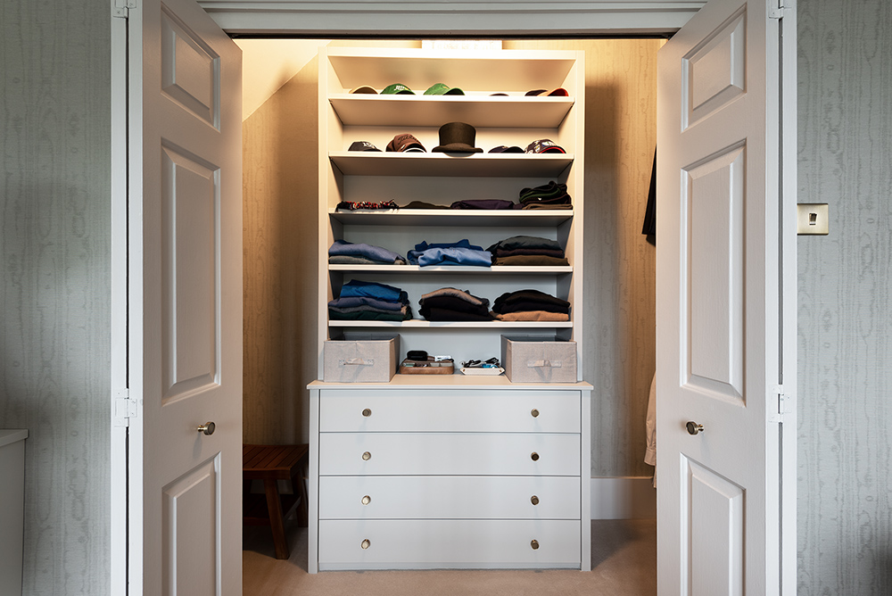 White built-in walk in wardrobe, made with MDF and hand-painted. Designed and installed by carpenters and joiners at Bespoke Carpentry London