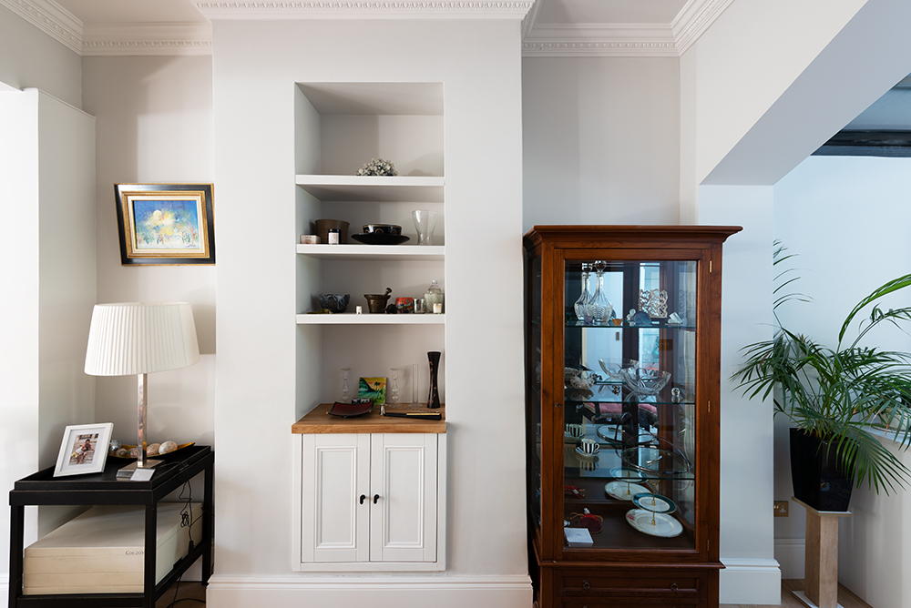 Built in cupboard and shelving in small alcove space in living room
