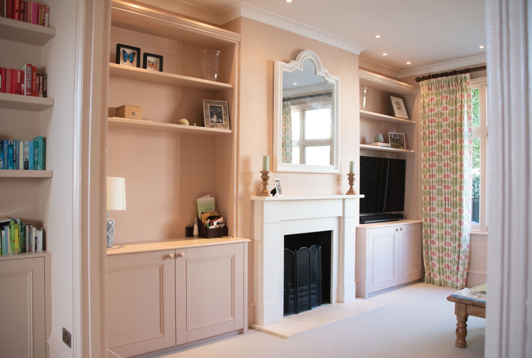 Fitted living room pink cabinets and shelving in alcoves