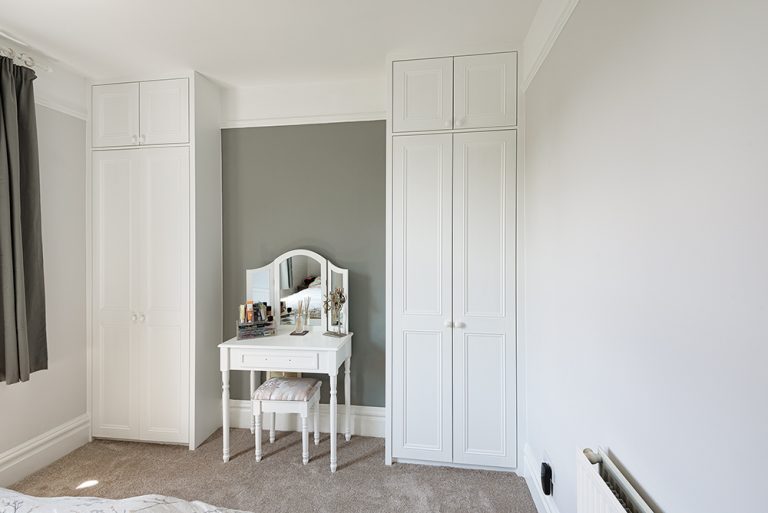 Fitted white alcove wardrobes with dresser in the middle