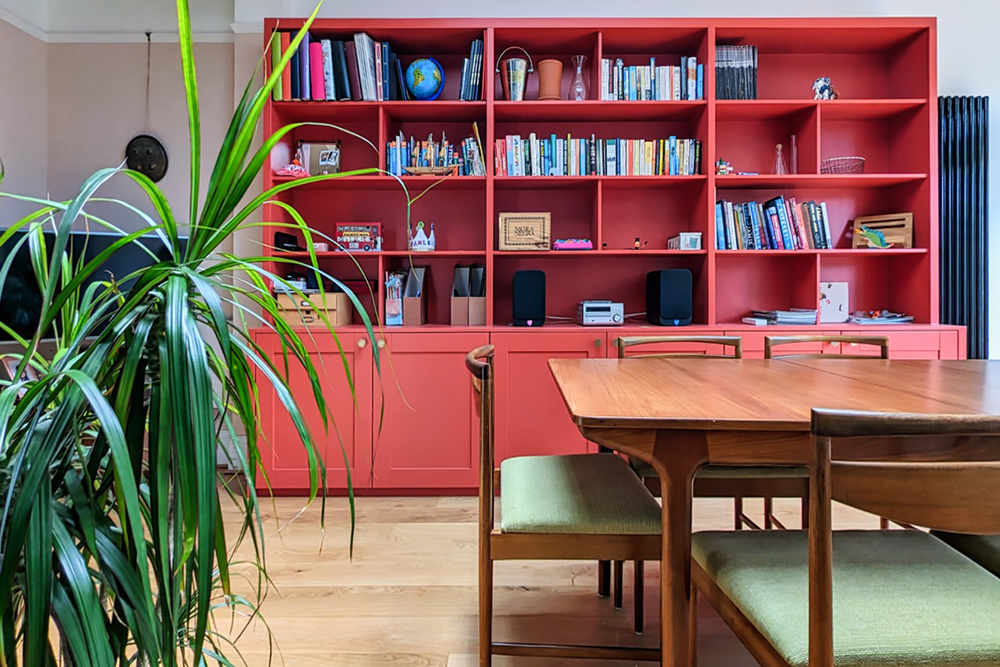 Large red built-in cupboard with 6 doors and shelving unit to store books in living space