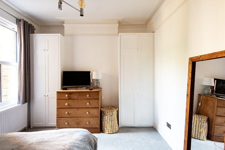 Built-in alcove wardrobes in bedroom. Designed and installed by Bespoke Carpentry London