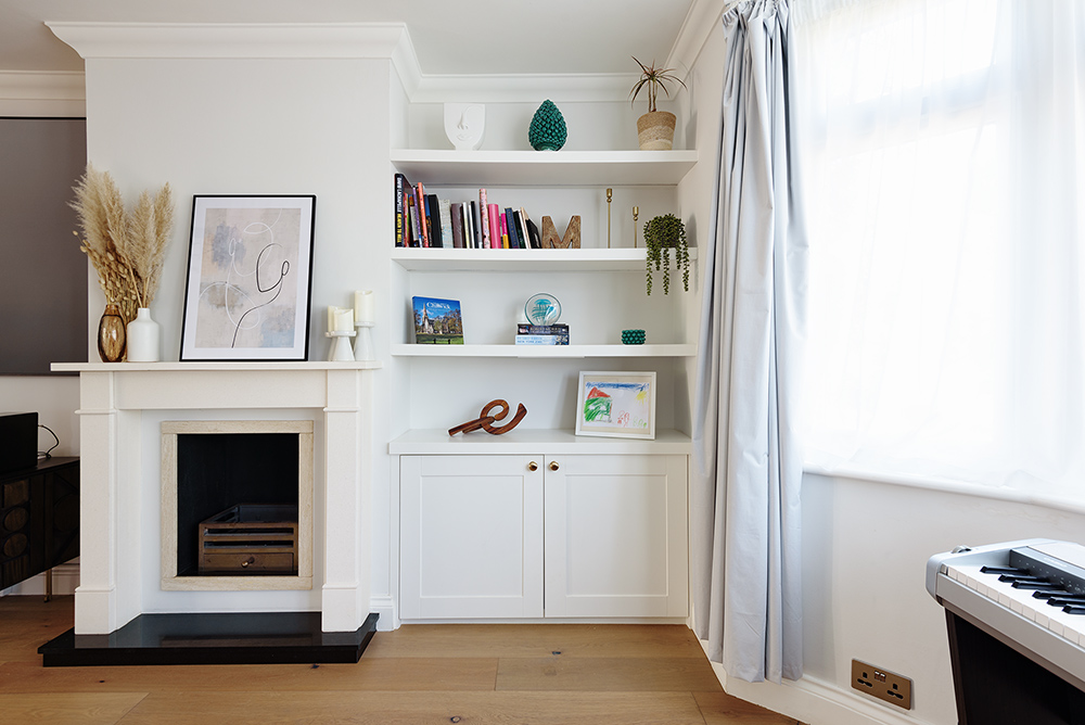 Built-in alcove cupboard with 3 floating shelves to store books, plants and personal belongings next to fireplace. Built by Bespoke Carpentry London