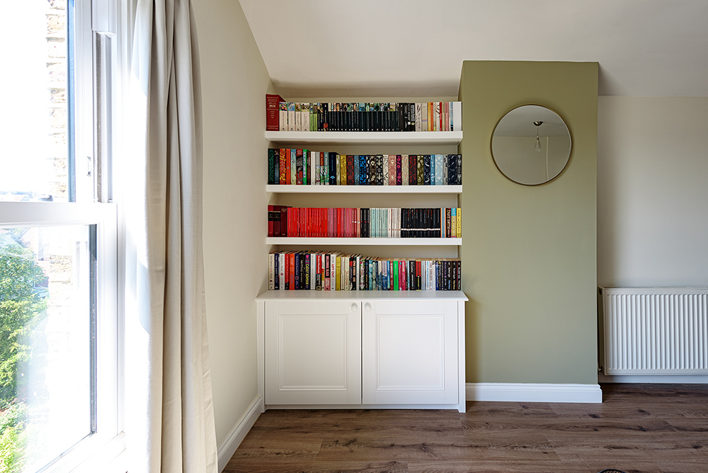 White floating shelves for books with cupboard
