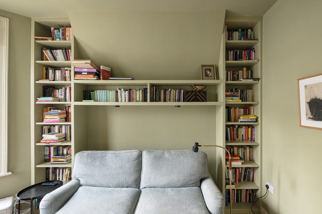 Built in shelving unit, shaped liked a T to store books.