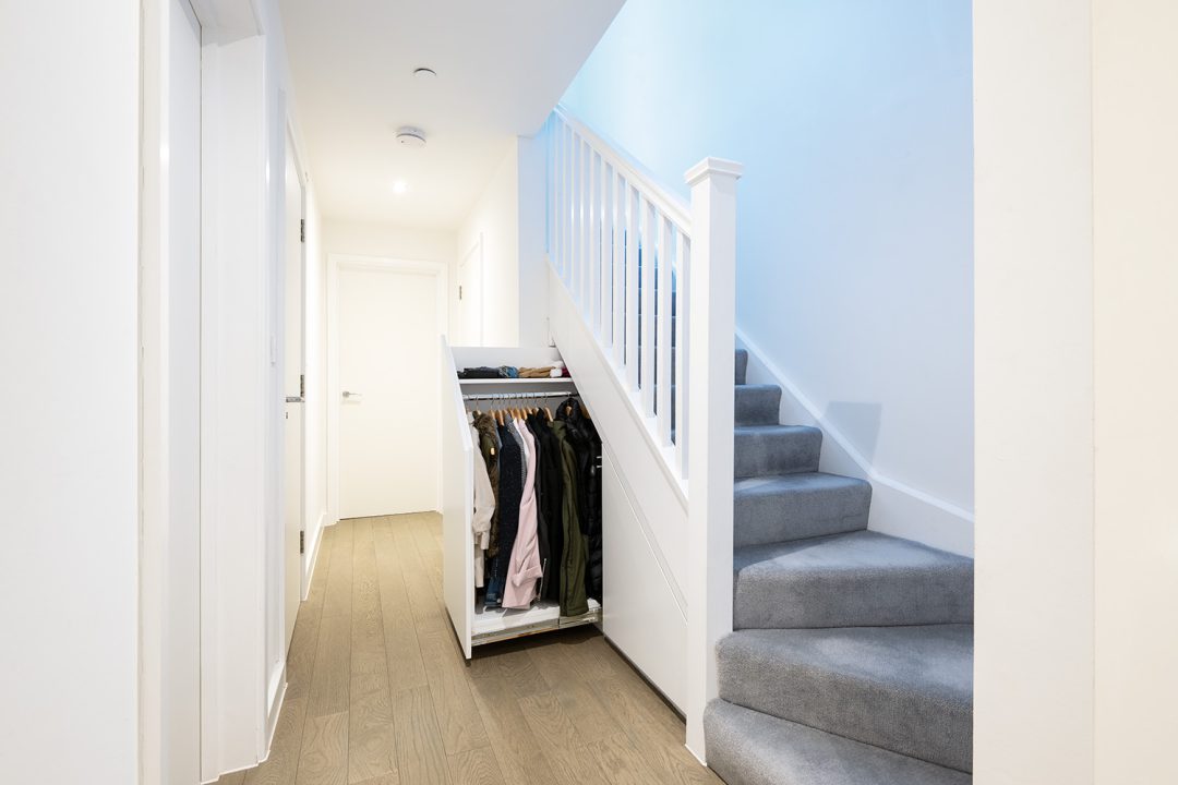 Built in under stairs storage to put extra jackets and coats