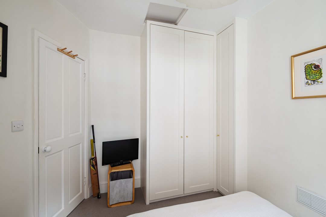 White 2 door fitted corner wardrobe in bedroom