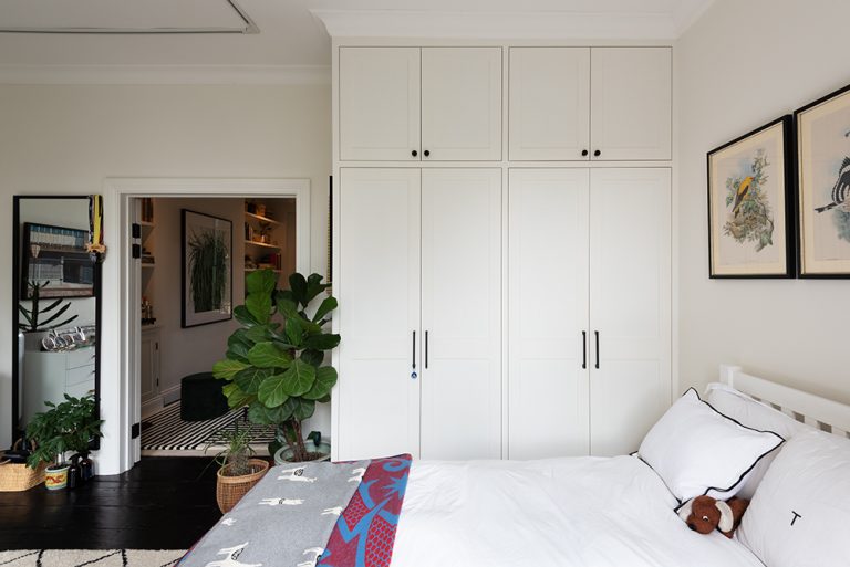 A white wardrobe with 4 doors and cupboard space at the top.