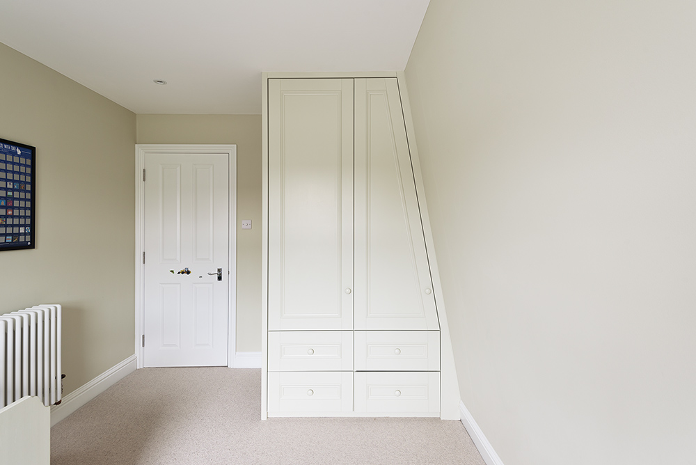 Bespoke wardrobe on a slanted wall in spare room