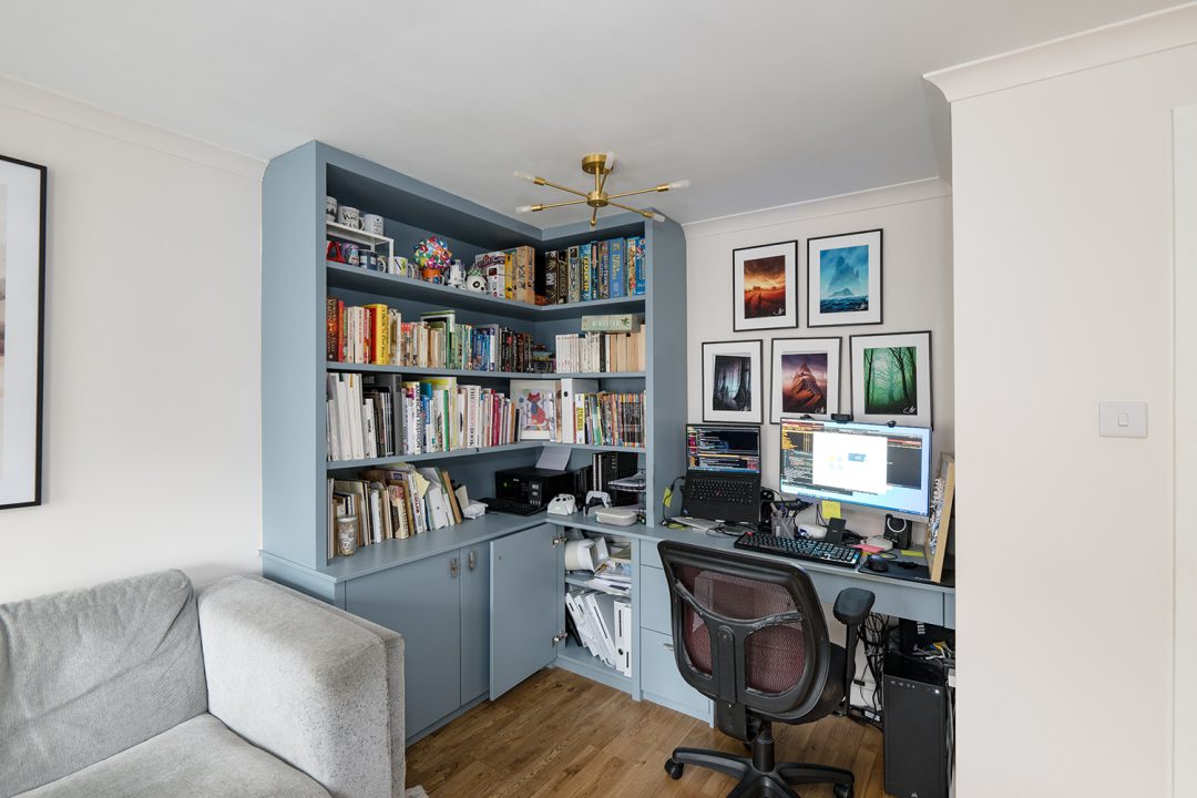 Fitted corner home office unit with desk, shelving and cupboards.