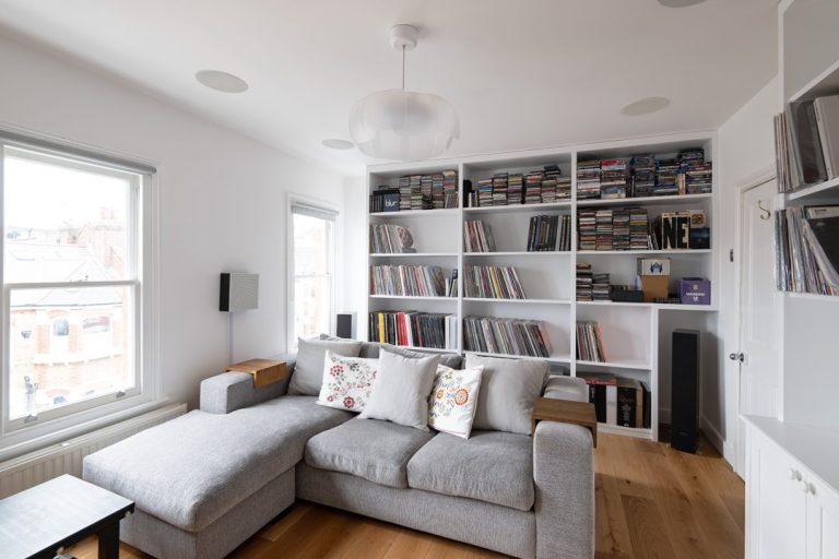 White built in shelving unit in living room to store music vinyls.