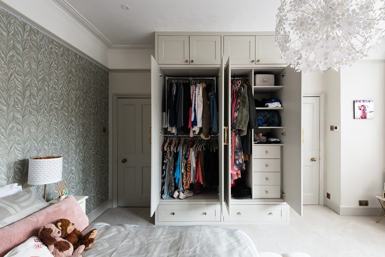 Modern bespoke wardrobe in bedroom, with the doors open. Designed and installed by Bespoke Carpentry London