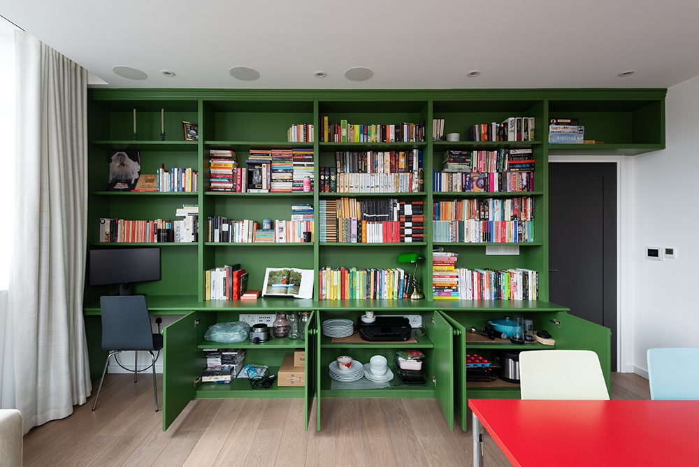 Built in green bookshelf with cupboards