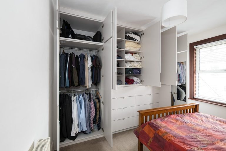 Large wall to wall wardrobe with wardrobe open.
