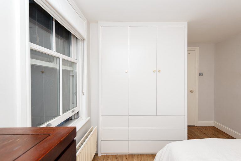 Modern white bespoke wardrobe with 3 doors. Designed and built from carpenters at Bespoke Carpentry London.