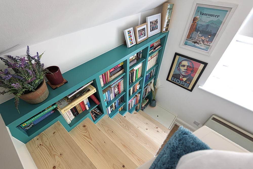 Green bookcase on stairs from cabin bed