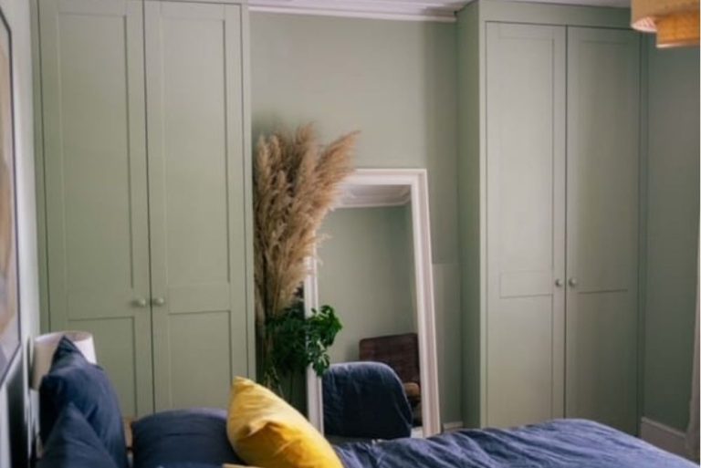 Green fitted alcove wardrobes in bedroom