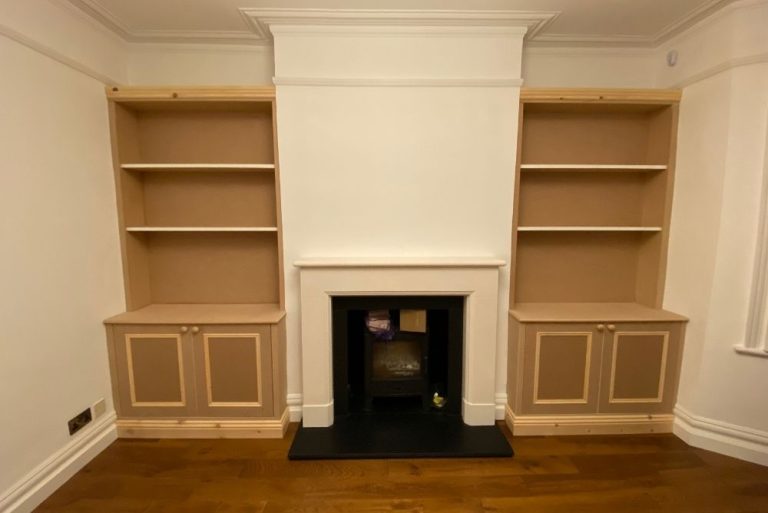 Built in alcove cupboards next to fireplace