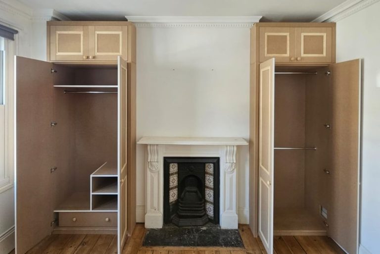 Fitted alcove wardrobe next to fireplace
