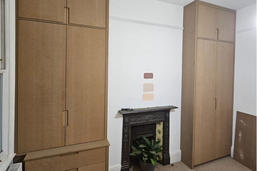 Two wardrobes next to fireplace