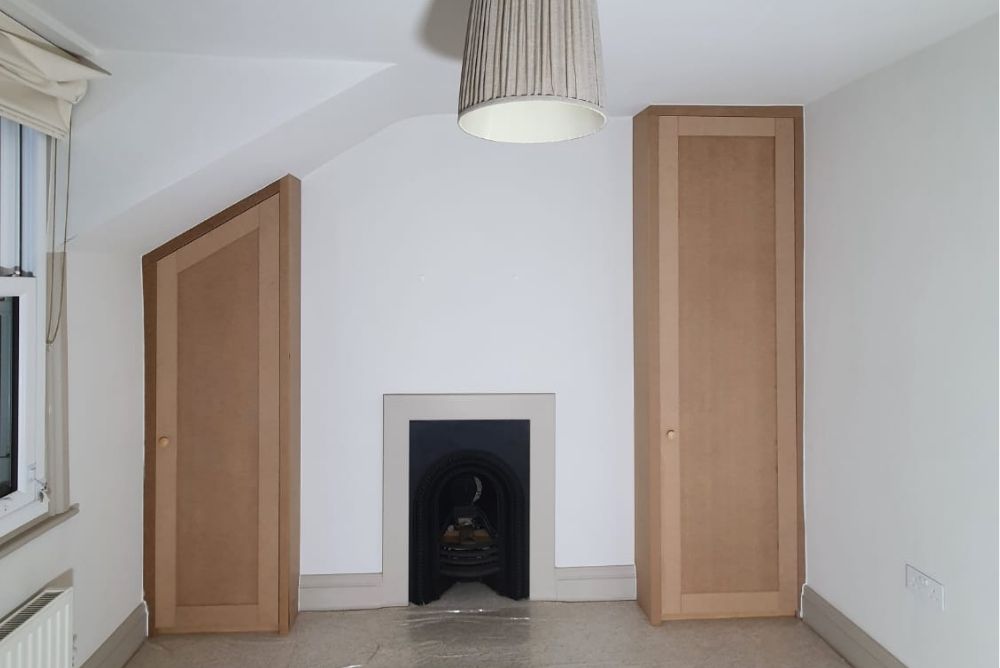two alcove wardrobes next to chimney