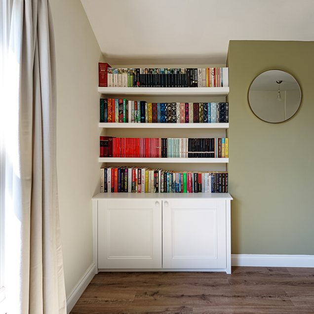 White built in alcove cupboard with floating shelves with books