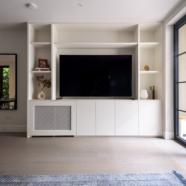 Built in white tv unit with cupboards for storage.